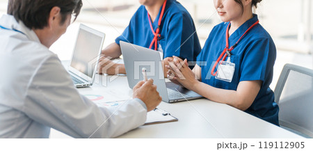 医局でカンファレンス・打ち合わせ・ミーティングする男女の医師・医者・ドクター・看護師（顔なし） 119112905