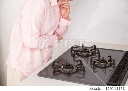 ガスコンロを見て悩むミドル女性 119113158