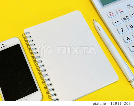 白いリングノートとスマホ、電卓 119114202