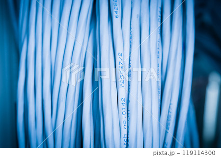 bunch of network cables in wave pattern leading across server ro 119114300