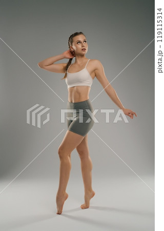Young dancer showcasing grace during studio performance in natural light Young dancer showcasing grace during studio performance in natural light 119115314