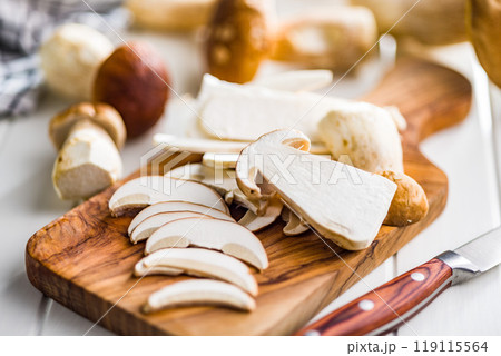 Fresh boletus mushrooms on cutting board on white table. Fresh boletus mushrooms on cutting board on white table. 119115564