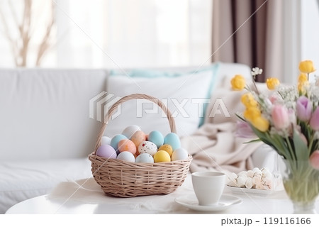 in a bright living room on a table with a white tablecloth, a wicker basket with Easter eggs in pastel colors 119116166