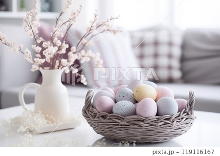 in a bright living room on a table with a white tablecloth, a wicker basket with Easter eggs in pastel colors 119116167
