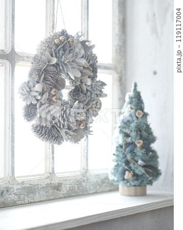 窓辺に飾られたクリスマスリースとクリスマスツリー 119117004