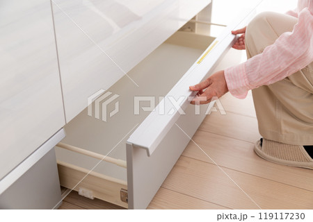 キッチンのキャビネット収納を見るミドル女性 119117230