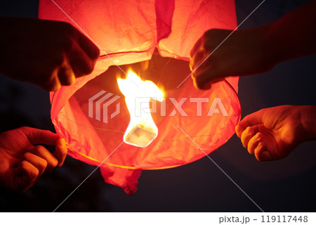 Couple Holding Sky Lantern And Launching It Couple Holding Sky Lantern And Launching It 119117448