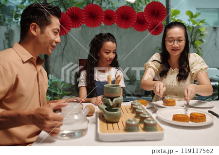 Family Eating Moon Cake At Autumn Holiday Family Eating Moon Cake At Autumn Holiday 119117562