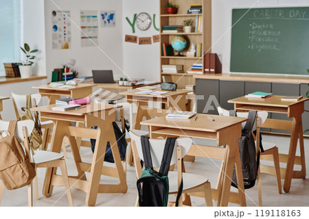 No people interior shot of modern classroom with notebooks and pencils on desks and students backpacks on chairs No people interior shot of modern classroom with notebooks and pencils on desks and students backpacks on chairs 119118163