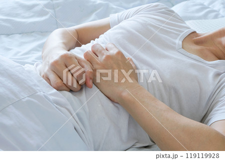 Young man uses his hands to hold his stomach and has a severe stomachache.on isolated white background Young man uses his hands to hold his stomach and has a severe stomachache.on isolated white background 119119928