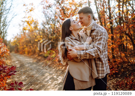 Couple in love newlyweds in casual clothes travel together, hike and walk in autumn forest in nature 119120089