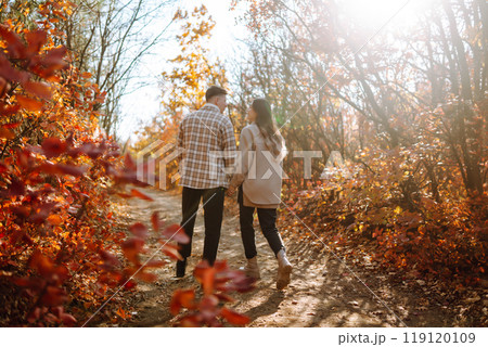 Couple in love newlyweds in casual clothes travel together, hike and walk in autumn forest in nature 119120109