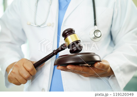 Asian doctor holding court hammer for and crime law justice, forensic medicine. Asian doctor holding court hammer for and crime law justice, forensic medicine. 119120349