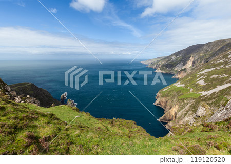 Slieve League cliffs stretch into the Atlantic, with grassy slopes, rocky outcrops and blue water 119120520