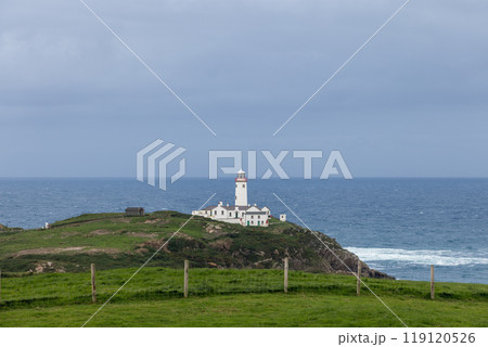 Fanad Head Lighthouse atop green cliffs, overlooking the ocean where the sea, sky merge on horizon Fanad Head Lighthouse atop green cliffs, overlooking the ocean where the sea, sky merge on horizon 119120526
