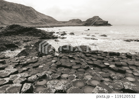 Vintage sepia photo of Giant's Causeway, featuring distinctive basalt columns and coastal hills 119120532