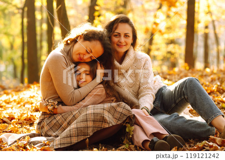 The homosexual family playing with her daughter in the autumn forest. The adventure is more fun. 119121242