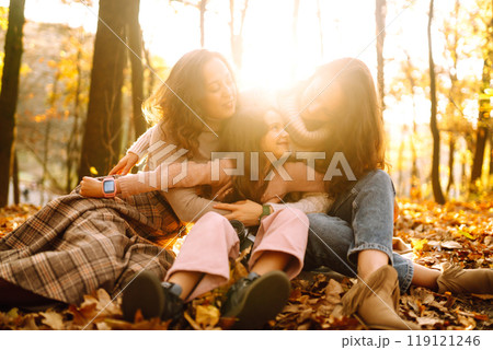 The homosexual family playing with her daughter in the autumn forest. The adventure is more fun. 119121246