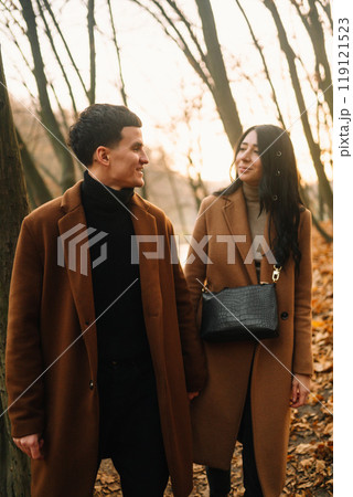 Young couple in love walking in the park on a autumn day. Enjoying time together. 119121523