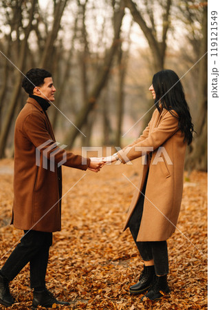 Young couple in love walking in the park on a autumn day. Enjoying time together. 119121549