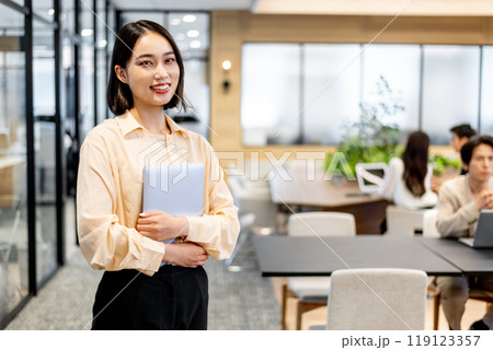 ノートパソコンを抱えて笑顔を見せる女性 119123357