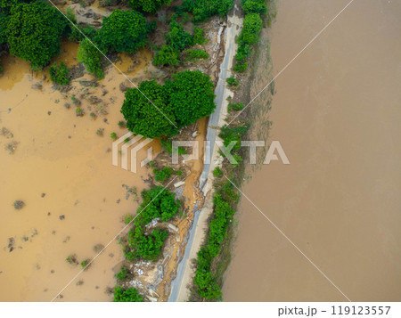 Landslides caused by heavy rains have caused the asphalt roads to crack. Natural disasters from flooding have damaged and cut off the road surface along the river. Landslides caused by heavy rains have caused the asphalt roads to crack. Natural disasters from flooding have damaged and cut off the road surface along the river. 119123557