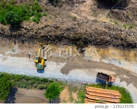 Landslides and natural disasters with excavators working on site. Natural disasters from flooding have damaged and cut off the road surface along the river. Landslides and natural disasters with excavators working on site. Natural disasters from flooding have damaged and cut off the road surface along the river. 119123570