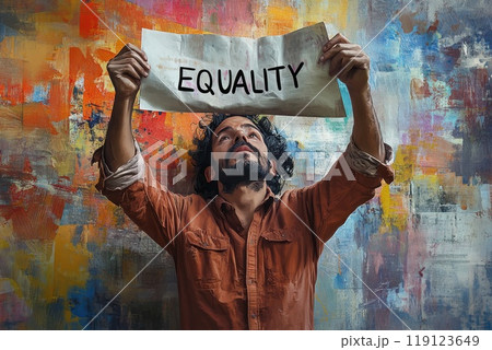 Latino man standing against colorful wall holding a paper with text Equality 119123649