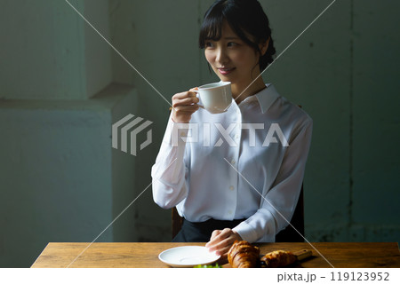 朝の落ち着いた雰囲気の中で一杯のコーヒーを飲む若い女性 朝の落ち着いた雰囲気の中で一杯のコーヒーを飲む若い女性 119123952