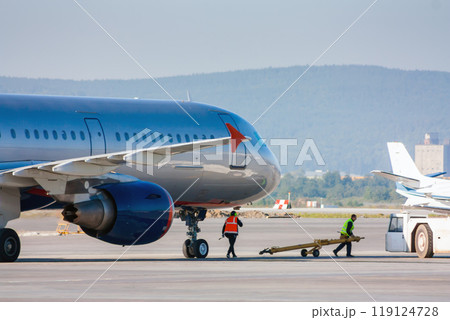 Preparing passenger airplane for tow tractor at the airport 119124728