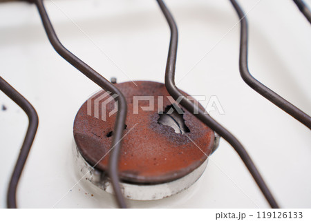 An old broken rusted burner of a gas stove.  119126133