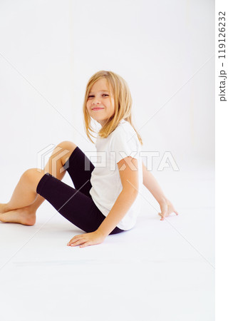 Cheerful teenage girl in white t-shirt and black breeches on white background 119126232