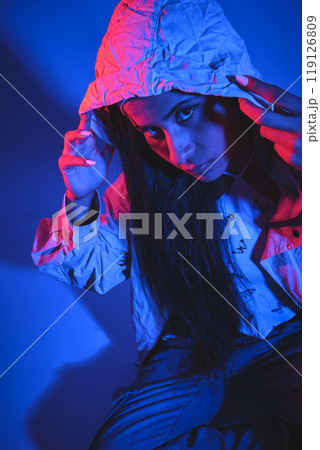 A woman with long hair is wearing a hooded jacket. hip hop concept 119126809