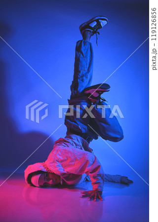 A man is doing a handstand on a white background. Urban concept. A man is doing a handstand on a white background. Urban concept. 119126856