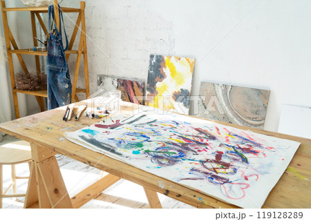 A Joyful Artist Proudly Showcasing Their Colorful Paint Brushes in a Bright and Inspiring Studio Environment A Joyful Artist Proudly Showcasing Their Colorful Paint Brushes in a Bright and Inspiring Studio Environment 119128289