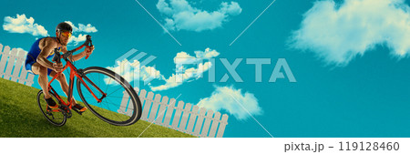 Cyclist leaning into sharp turn on grassy slope, against backdrop of fence and clear blue sky. Creative art collage. 119128460