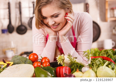 Woman having vegetables on table 119128907