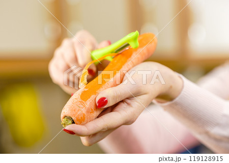 Woman peeling carrot vegetable 119128915