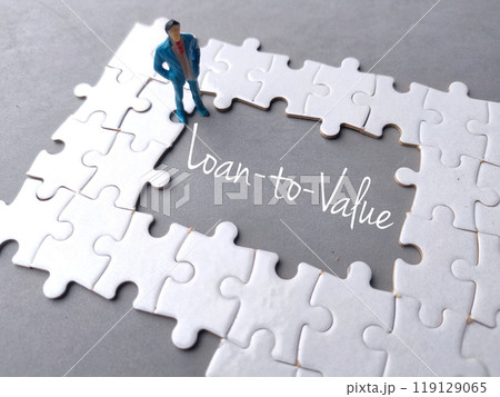 Text Loan to Value written on gray background with white puzzle and miniature people. Text Loan to Value written on gray background with white puzzle and miniature people. 119129065