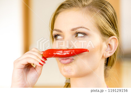 Woman holding chilli hot pepper 119129156