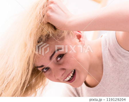 Woman playing with blonde hair 119129204