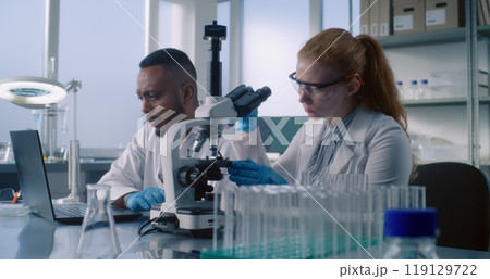 Diverse team of biotechnology scientists develop drugs in advanced medical science lab 119129722