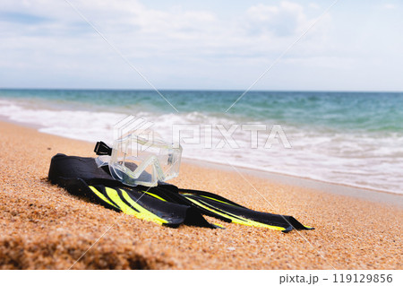 On the golden sea beach lie a snorkel mask and fins. Concept of snorkeling at sea 119129856