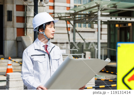 工事現場で図面を確認する現場監督 工事現場で図面を確認する現場監督 119131414