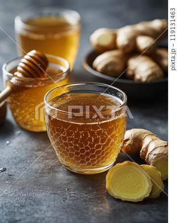 Refreshing honey and lemon drink with ginger, elegantly arranged on a textured surface 119131463