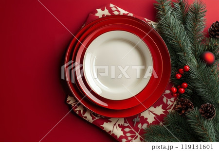 Festive red plates arranged for a holiday gathering with decorations and ornaments nearby 119131601