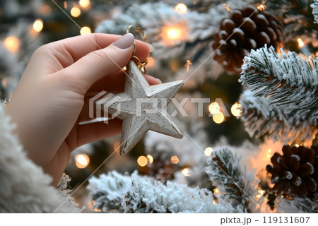 Decorating a festive tree with a handmade star ornament during the holiday season 119131607