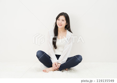 スキニージーンズ・ジーパン・デニムパンツをはいて胡座をかいて座る若い女性 スキニージーンズ・ジーパン・デニムパンツをはいて胡座をかいて座る若い女性 119135549