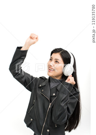 ヘッドホンで音楽を聴いて盛り上がる革ジャンを着た若い女性 119135780
