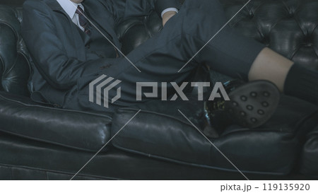 ソファに座るスーツの男性 119135920